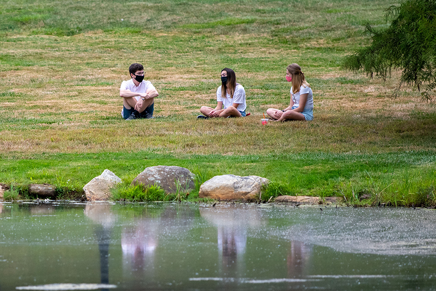 students sitting by a lake